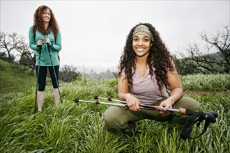 Portrait of smiling women hiking with walking sticks