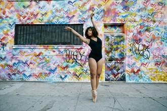 Mixed race ballet dancer on sidewalk