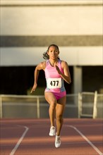 Female runner competing on racetrack