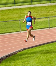 Japanese runner running on racetrack