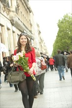Smiling Caucasian woman walking with bouquet
