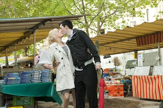 Caucasian couple kissing in market