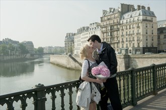 Caucasian couple kissing on bridge