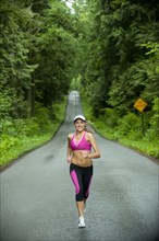 Caucasian woman running on remote road