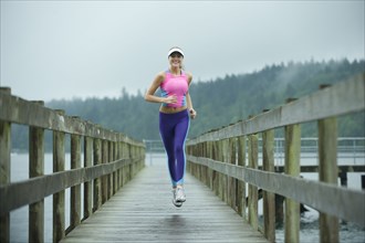 Caucasian woman running on pier