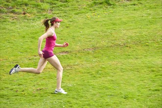Mixed race woman running in field