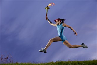 Caucasian athlete running with Olympic torch