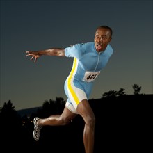 Black runner crossing finish line in race