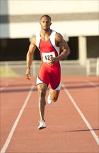 Black runner running on track