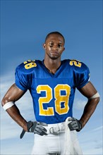 Black football player standing with hands on hips