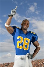 Black football player standing with arms raised