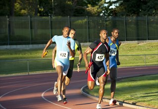 Relay racers running on track in race