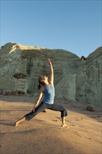 Caucasian woman practicing yoga in desert
