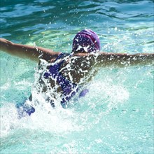 Caucasian teenager swimming in swimming pool