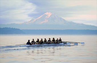 Team rowing boat in bay