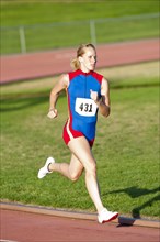 Caucasian runner running on track