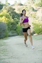 Hispanic woman running on remote path