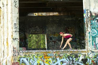 Caucasian woman stretching in abandoned loading dock