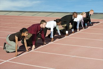 Business people crouching at starting line on track