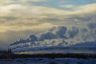 Distant power plant in arctic landscape