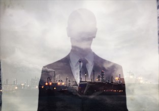 Double exposure of businessman and power plant