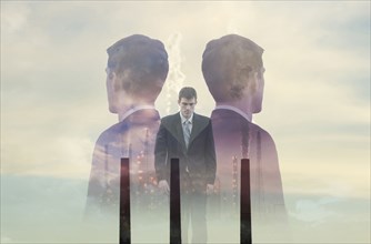 Double exposure of businessmen and smoke stacks