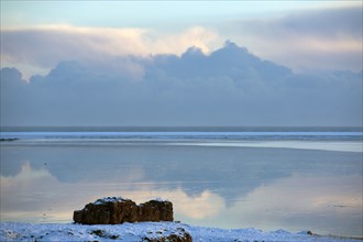 Clouds reflected in still ocean in arctic landscape