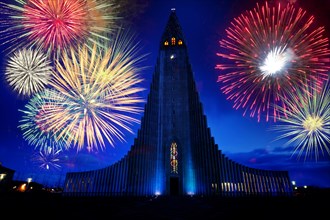 Fireworks exploding over monument in night sky