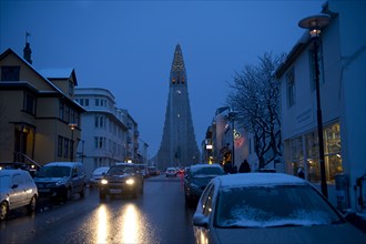 Monument overlooking Reykjavik city street at dusk