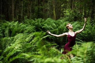 Caucasian woman dancing in forest