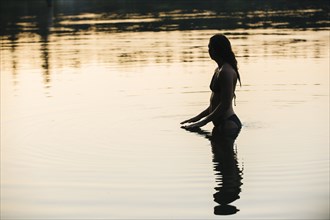 Korean woman standing in still lake