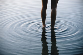 Reflection of legs of Korean woman with ripples in water