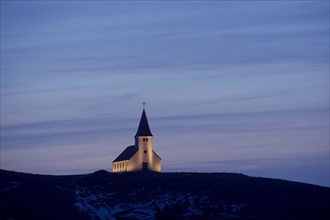 White church illuminated in remote landscape