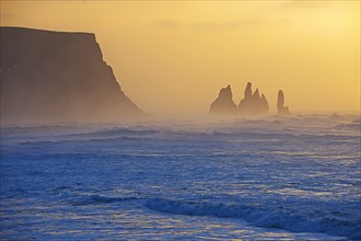 Silhouette of rock formations in misty ocean