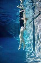Teenage girl swimming underwater in pool