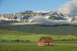 Mountains over barn in rural landscape