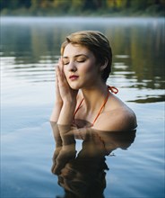 Caucasian woman sleeping in still lake