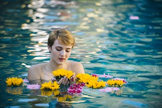 Woman playing with flowers in lake