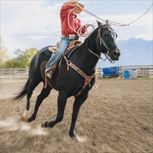 Caucasian boy using lasso on horse at rodeo