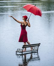 Caucasian woman standing on bench in flood