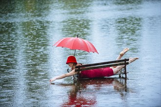 Caucasian woman laying on bench in flood