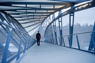 Caucasian businessman walking on sky bridge