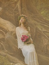 Caucasian woman holding bouquet of flowers in forest