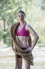 Serious Caucasian woman carrying heavy ropes