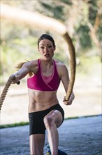 Caucasian woman working out with heavy ropes