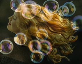 Bubbles floating near smiling Caucasian woman