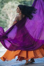 Belly dancer holding purple fabric