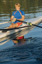 Caucasian man rowing on river