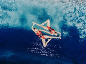 Aerial view of Caucasian synchronized swimmers