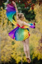 Caucasian ballerina leaping in park